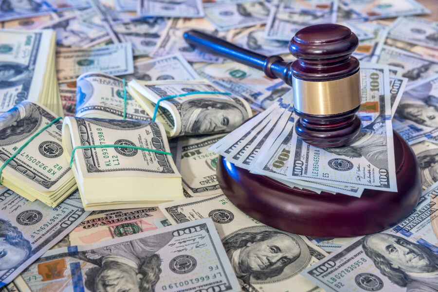 Auction concept - judges gavel against us dollar background indicating a financial crime.